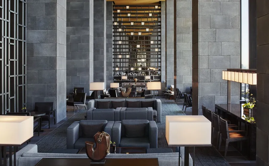The monumental 30-meter high lobby atrium of Aman Tokyo, mimicking the interior of a traditional paper washi lantern with a central ikebana arrangement and rock garden.
