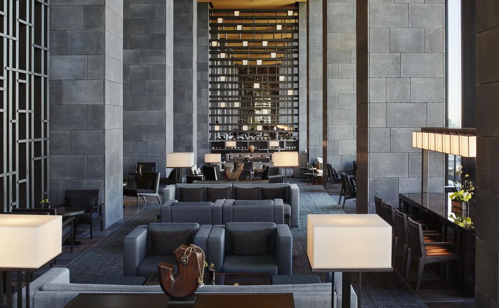 The monumental 30-meter high lobby atrium of Aman Tokyo, mimicking the interior of a traditional paper washi lantern with a central ikebana arrangement and rock garden.