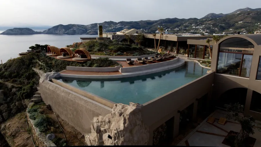 Earth-toned clifftop suites and infinity pools at Acro Suites overlooking the Aegean Sea at Mononaftis Bay, Crete.