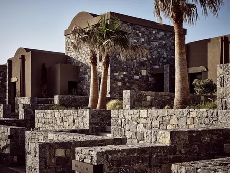 Clifftop terraces and volcanic stone architecture at Acro Suites, Crete.