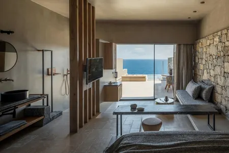Earth-toned suite interior with Aegean views at Acro Suites.